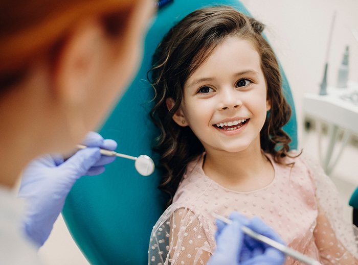 young girl smiling while visiting dentist 