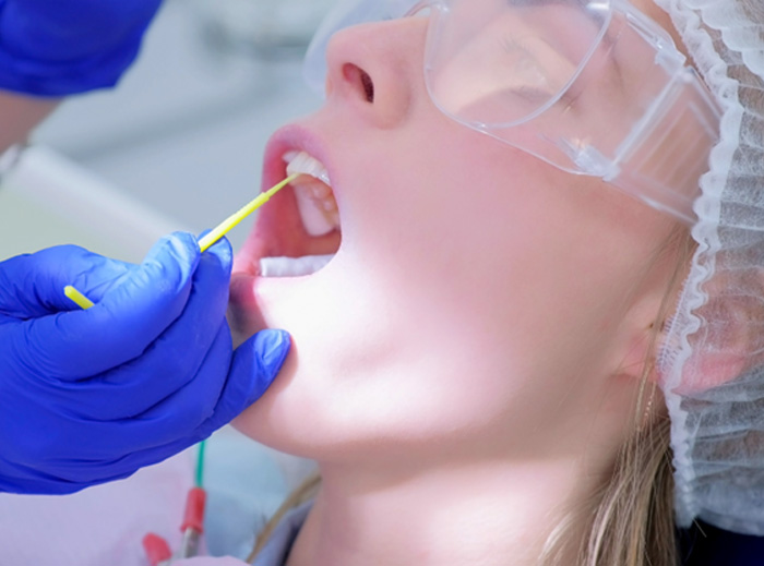 Child receiving fluoride during checkup 