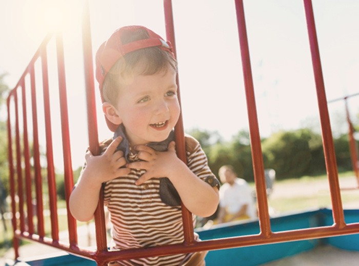 Little boy playing on the playground and smiling 