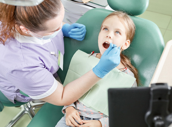 Dentist using ICON resin infiltration on young patient 