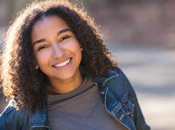 Young girl smiling while outside 