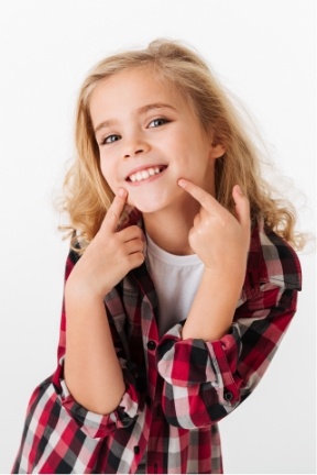 Child pointing to flawless smile after cosmetic dentistry for kids