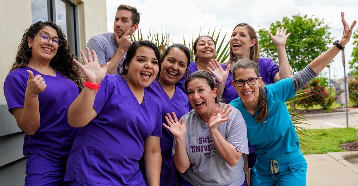 Pediatric dental team giving thumbs up