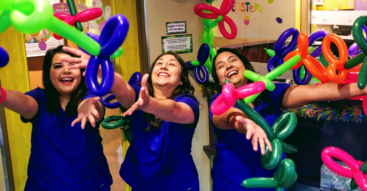 Pediatric dental team members with balloon animals