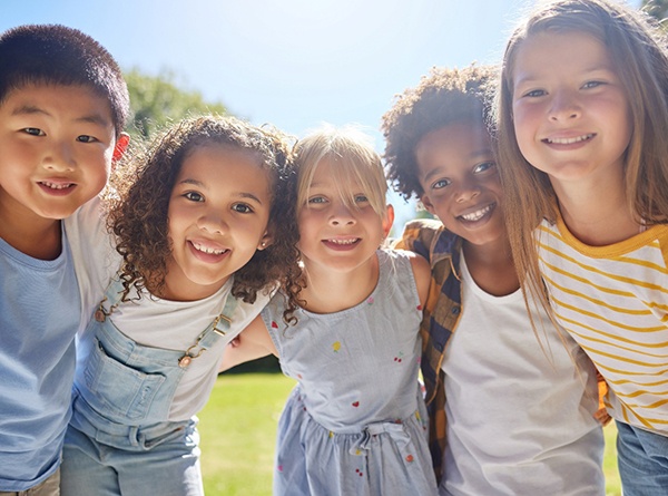 A group of young children hugging and smiling