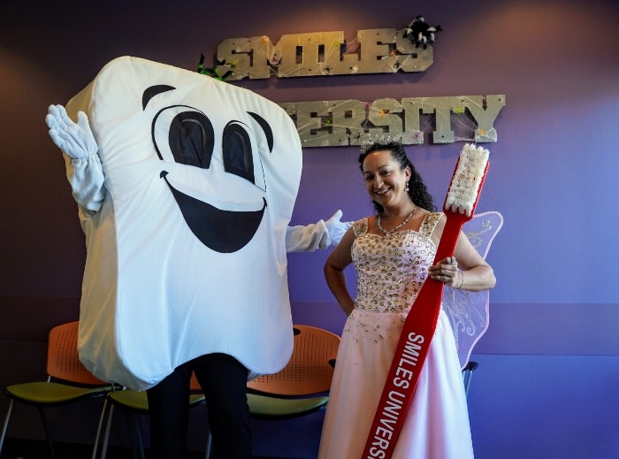 Sparkles the tooth fairy with a dental team member in a tooth mascot suit