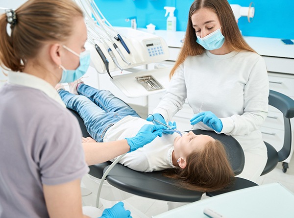 Dentist and dental hygienist placing a dental crown