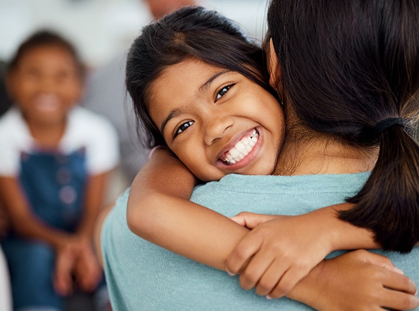 Little girl hugging her mom and smiling