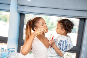 a parent and child brushing their teeth 